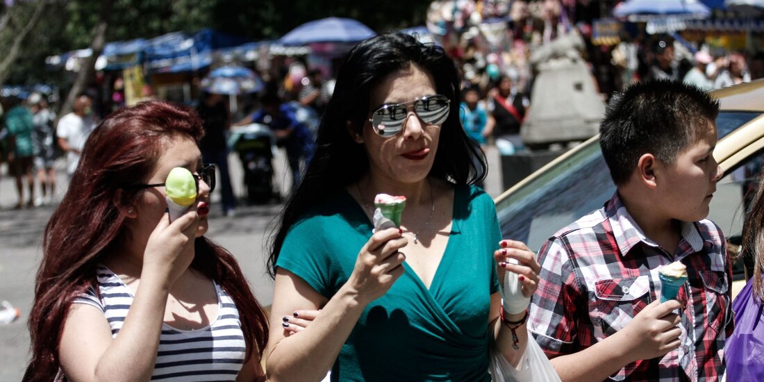 Turistas disfrutan de un helado para combatir el fuerte calor que se siente en la Ciudad de México.