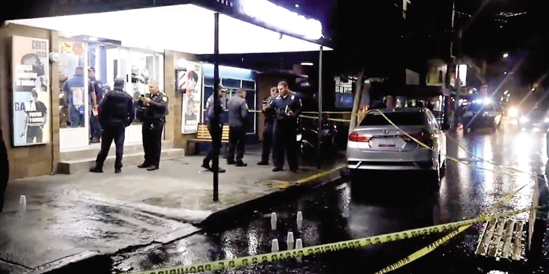 Policías resguardan la barbería Studio 10 tras un ataque a disparos, en 2025.