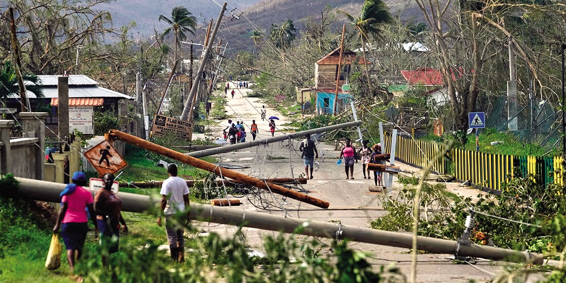 Residentes caminan por Lacovia Tombstone, Jamaica, tras el paso del huracán Melissa, ayer.