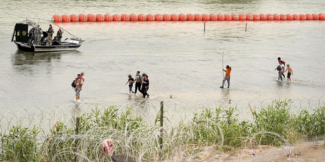 Migrantes intentan cruzar el río Bravo, ayer, donde Texas puso boyas.