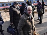 Ucranianos salen de un tren que transportaba a 275 personas para llegar a Zahony, Hungría, ciudad fronteriza con Ucrania.