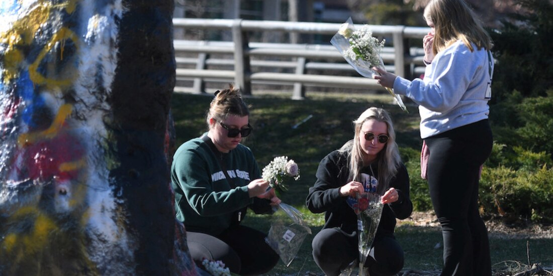 Estudiantes colocan flores en el campus de la Universidad Estatal de Michigan después del tiroteo, ayer.