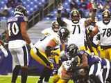 jugadores de Acereros y Cuervos pelean el balón antes de una anotación, ayer, en el M&T Bank Stadium.