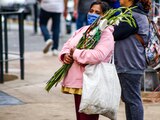 Una mujer carga la imagen de San Judas Tadeo afuera de la iglesia de San Hipólito.