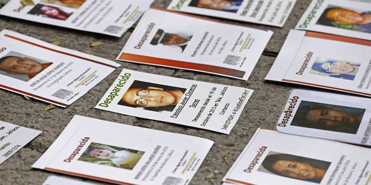 Carteles con fotos de personas desaparecidas sobre la banqueta donde se realizo un mural con la misma temática, esto en el marco del Día Internacional de la Victimas de Desapariciones Forzadas en 2020