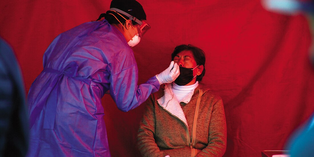 Una médica realiza una prueba de SARS-CoV-2 a una mujer, en 2022.