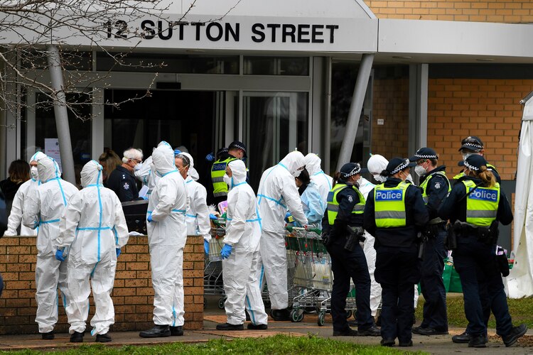 Bomberos se preparan para distribuir alimentos en una torre de viviendas públicas, encerrados en respuesta a un brote de COVID-19, en Melbourne, Australia, el 7 de julio de 2020.