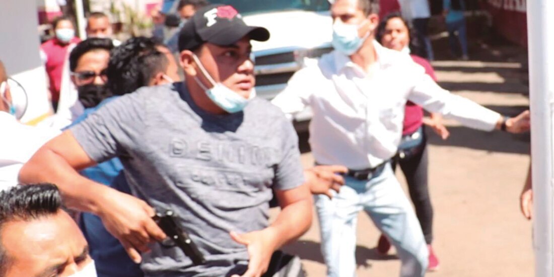 Hombre muestra arma de fuego para amenazar a funcionarios, ayer en Oaxaca.