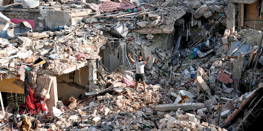 UN HOMBRE que regresa a su aldea hace el signo de la victoria sobre los escombros de su casa, destruida en Nabatiyeh, Líbano, ayer