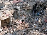 UN HOMBRE que regresa a su aldea hace el signo de la victoria sobre los escombros de su casa, destruida en Nabatiyeh, Líbano, ayer