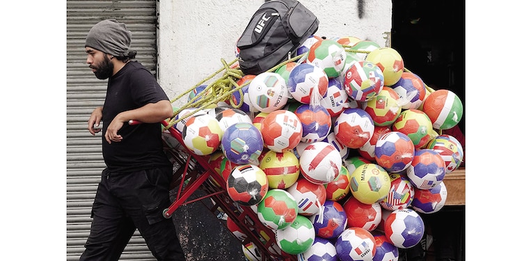 Un hombre transporta balones de futbol ante la cercanía del Mundial 2026, en la CDMX, en enero.