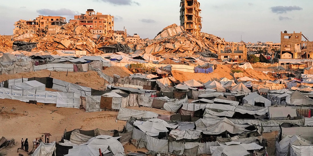Tiendas de campaña de palestinos desplazados entre edificios derrumbados, ayer.