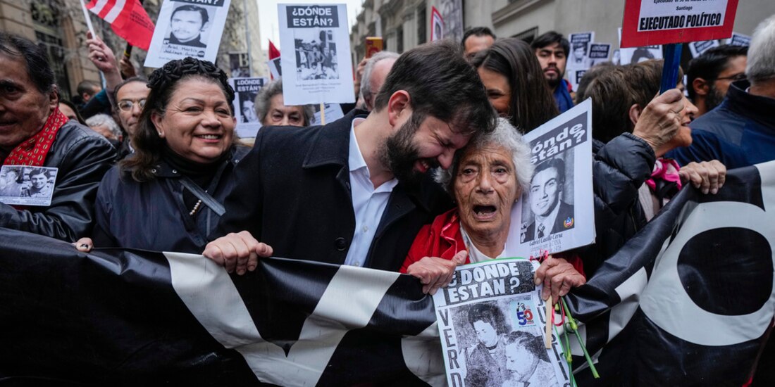 El presidente de Chile, Gabriel Boric (centro), participa en una manifestación con familiares de detenidos en la dictadura de Pinochet.