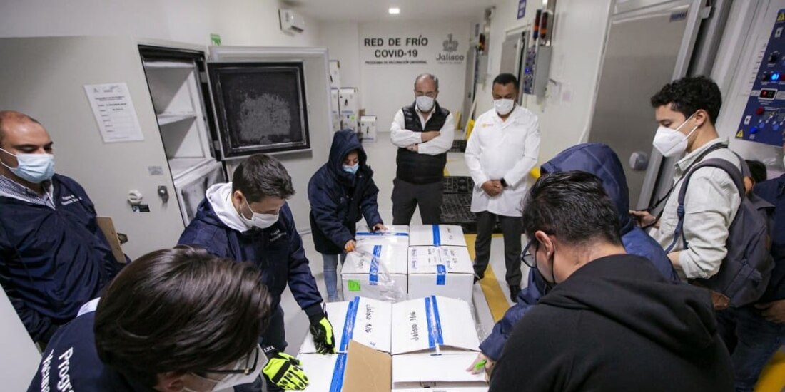 Personal de la Secretaria de Salud de Jalisco revisa el paquete de vacunas contra COVID-19.