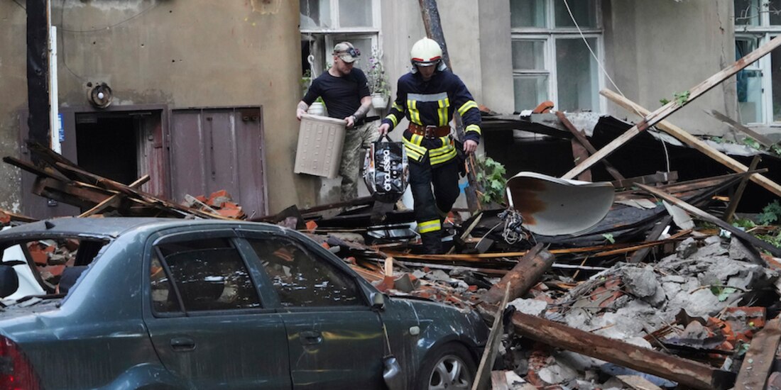 Un bombero ayuda a un ciudadano a recuperar sus pertenencias en un edificio bombardeado, ayer, en Sumi.