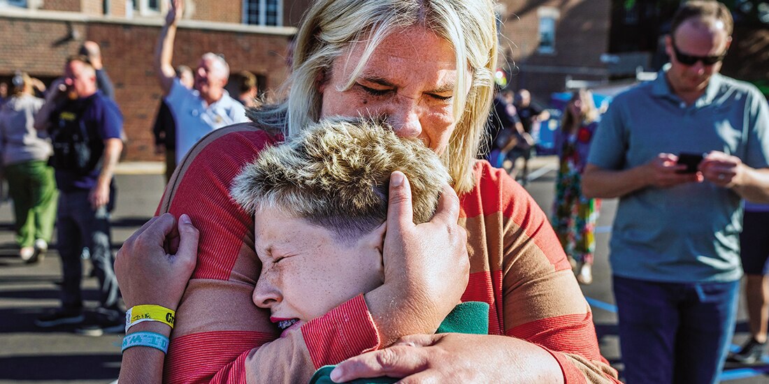 Una madre abraza a su hijo durante la agresión en la Iglesia de la Anunciación, ayer.