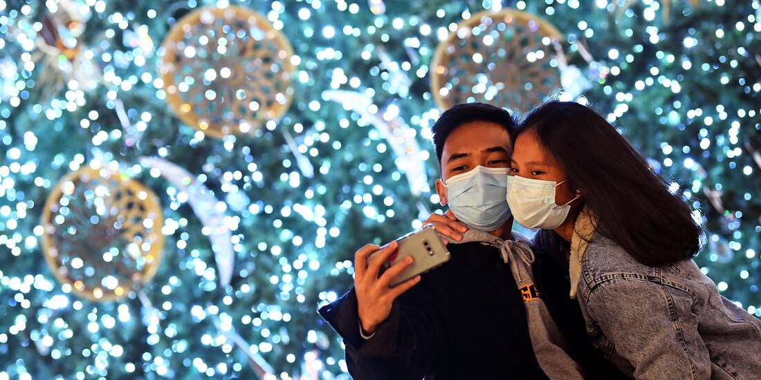 Navidad 2020. Parejas y familias se congregan junto a las decoraciones monumentales en vísperas de Nochebuena, en Milán, Italia.