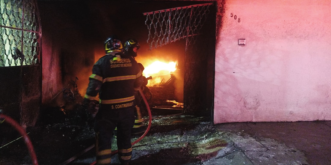 Bomberos sofocan las llamas dentro de la vivienda, este miércoles.