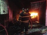 Bomberos sofocan las llamas dentro de la vivienda, este miércoles.