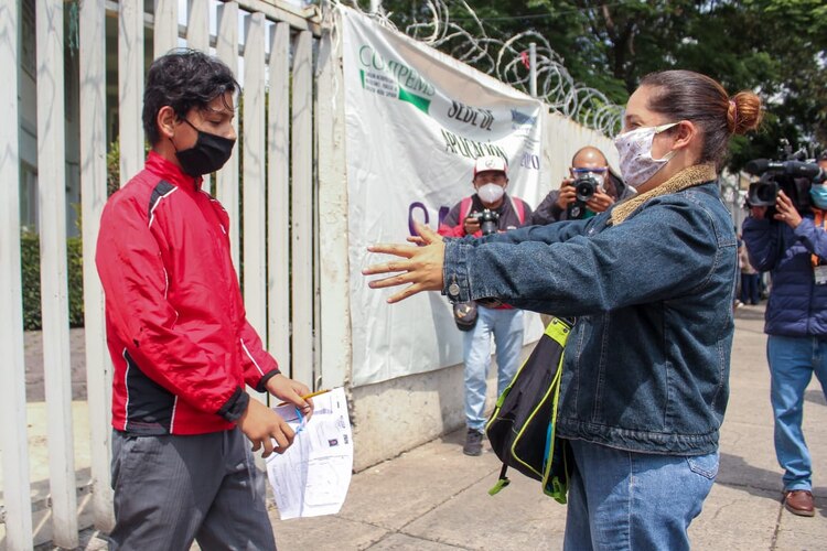 Una madre se dispone a abrazar a su vástago a las afueras de un centro educativo