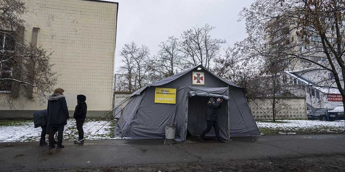 Unas personas de pie frente a una tienda de campaña con calefacción en Kiev, Ucrania, el lunes 28 de noviembre de 2022