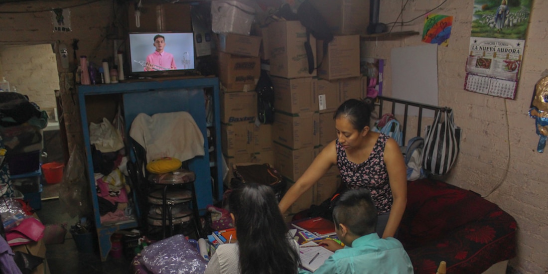 Alondra ayuda a sus hijos Ximena, de tercero de secundaria, y Gustavo, de sexto de primaria, en sus TV clases, ayer en Iztapalapa.