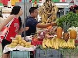 Dos personas compran alimentos en un local de frutas