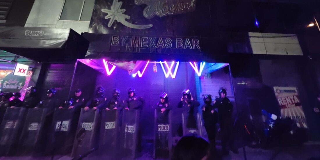 Policías locales resguardan un negocio suspendido.