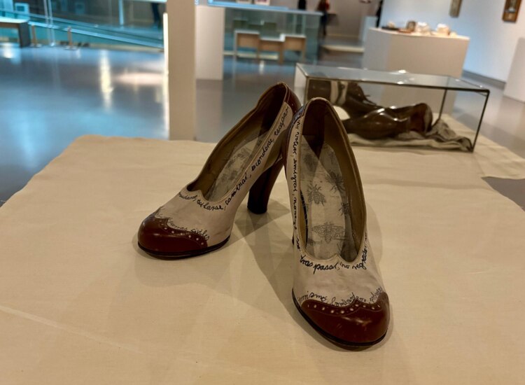 Zapatos rojos de tacón, intervenidos con escritura.