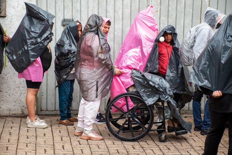 Fans esperan bajo la lluvia entrar a Casa Paquita