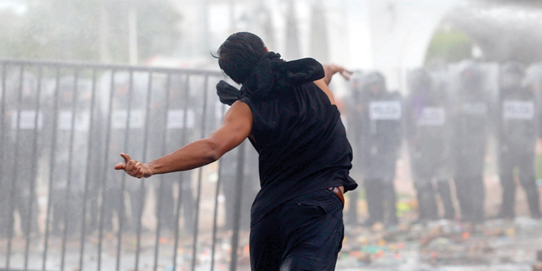 INTEGRANTE del grupo de atacantes en la marcha, en una acción de agresión.