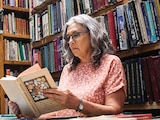 Mujer hojea un libro en una librería de Donceles, CDMX, en foto de archivo.