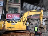 Los rescatistas trabajan junto a una excavadora en un sitio donde se derrumbó un edificio en Changsha, China.
