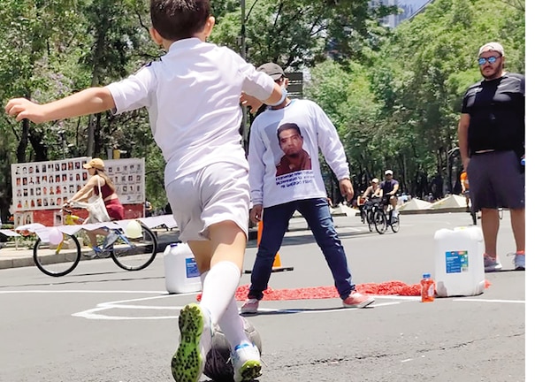 Un par de niños juegan futbol en la Glorieta de las y los Desaparecidos, en Reforma, ayer.