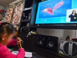 Una niña toma clases por televisión, ante la pandemia de COVID-19.