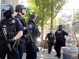 Policías de Seattle con armas hacen guardia frente al edificio del Precinto Este de Seattle, en esta fotografía de archivo del domingo 19 de julio de 2020. Los manifestantes rompieron ventanas del edificio a primera hora de la tarde.