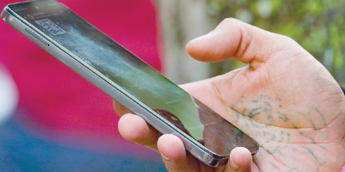 Uh hombre sostiene un teléfono celular, en la Ciudad de México. │ Cae compra de celulares
por registro obligatorio