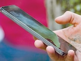 Uh hombre sostiene un teléfono celular, en la Ciudad de México. │ Cae compra de celulares
por registro obligatorio