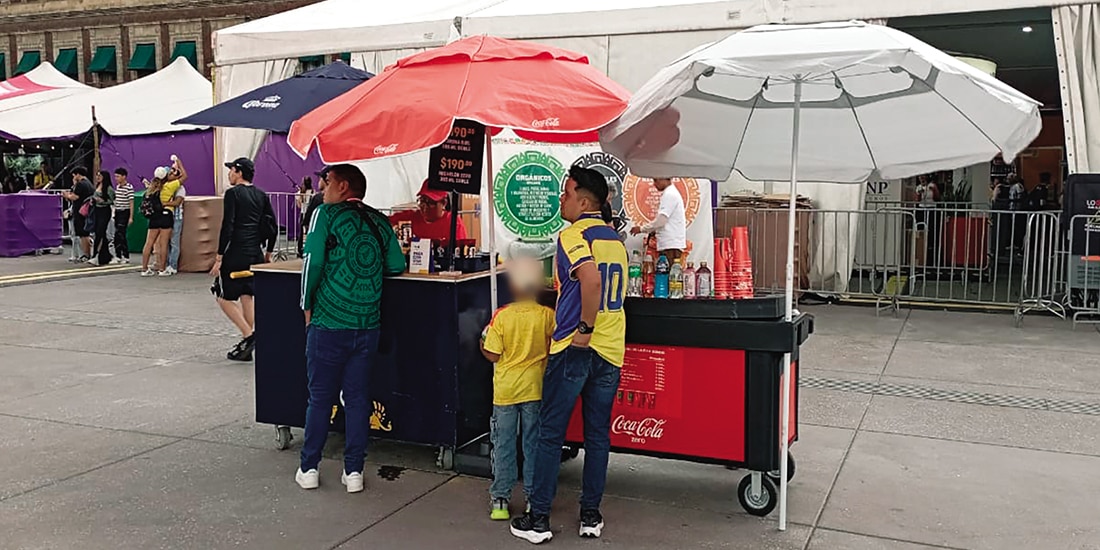 Un padre y su hijo compran bebidas en un carrito con cerveza y refresco, ayer.