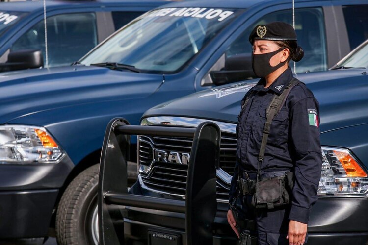 Una oficial de la Policíaa guerrerense con los vehículos entregados.