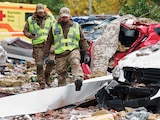 Policías caminan frente a autos destruidos por un ataque con drones rusos en Kiev, ayer.