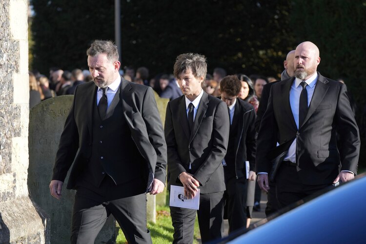 Louis Tomlinson en el funeral de Liam Payne, sostiene un panfleto