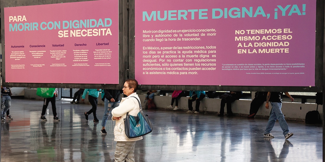 Una adulta mayor recargada en una exposición sobre la muerte digna, en noviembre pasado en el Metro Cuatro Caminos.