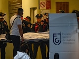 Policías bancarios trasladan el cuerpo de la víctima tras el atentado, ayer.