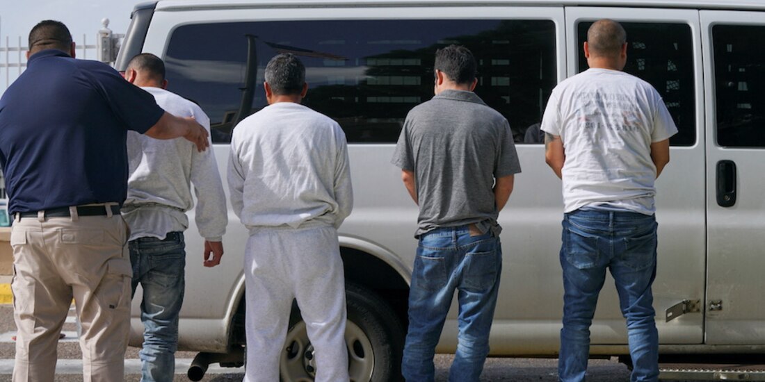 Indocumentados sujetos a deportación, con esposas en los pies.
