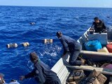 Elementos de la Marina recogen del mar los paquetes que abandonaron los delincuentes.