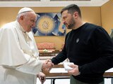 Volodímir Zelenski (der.) estrecha la mano del Papa Francisco (izq.).