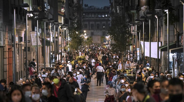 Personas caminan por la calle con cubrebocas para protegerse del Covid-19