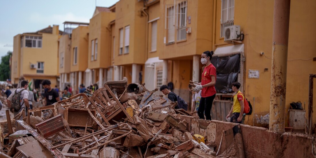 Voluntarios se unen a vecinos para retirar los escombros y el lodo acumulado por la peor DANA en poblados de Valencia, ayer.
