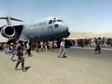 Cientos de personas corren al rodar de un avión en el aeropuerto de Kabul, ayer.